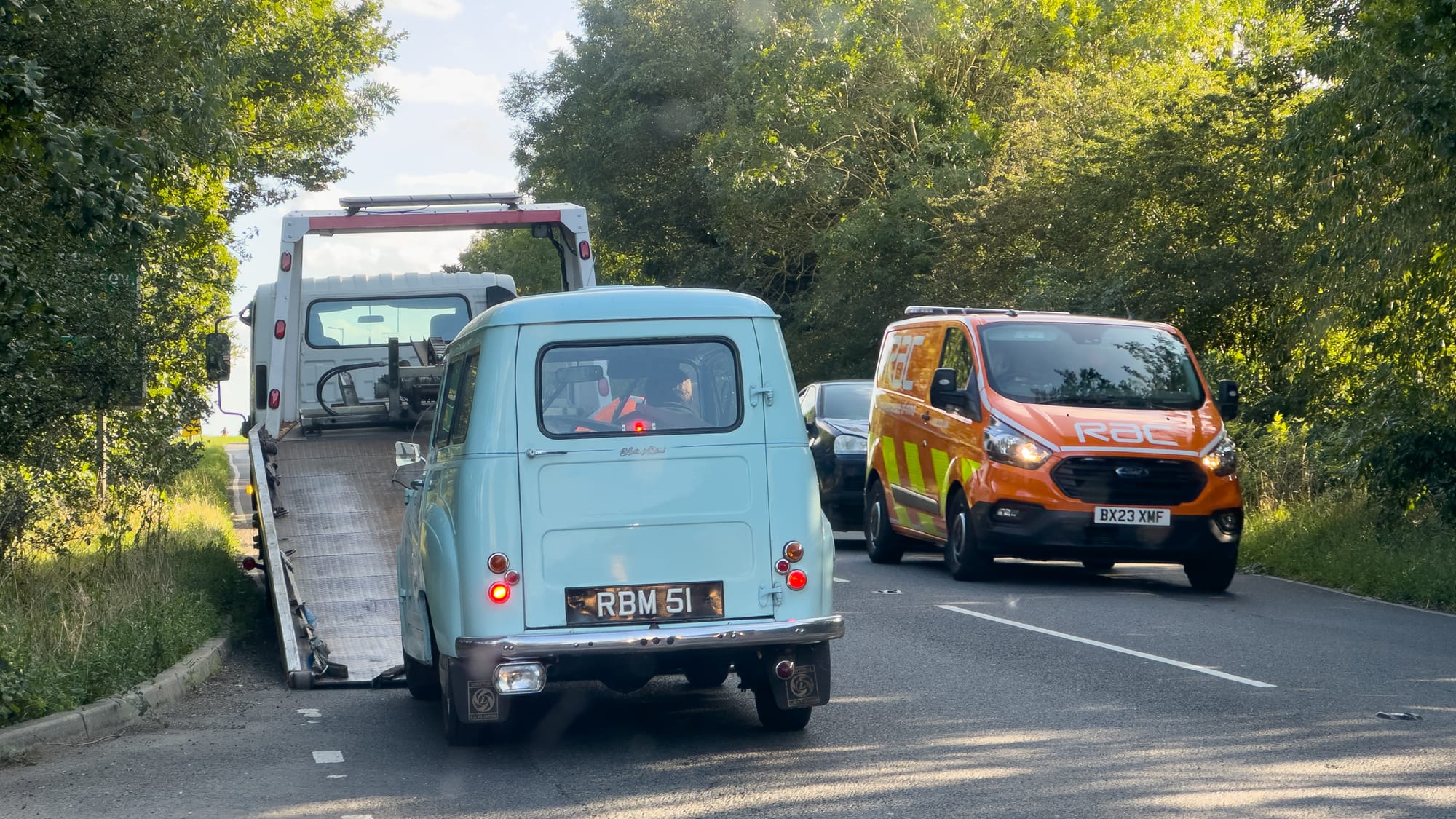 Austin A30 van being loaded onto back of recovery truck